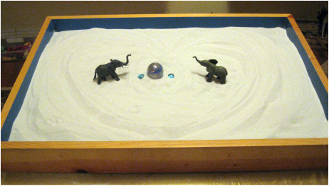 Sandplay table with toy elephants and marbles